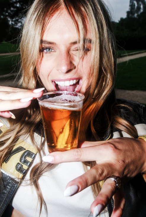 Festivalbezoeker drinkt uit een herbruikbare beker in het park